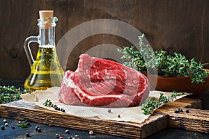 Raw beef marble tenderloin.Raw beef fillet on a rustic table with thyme and olive oil.