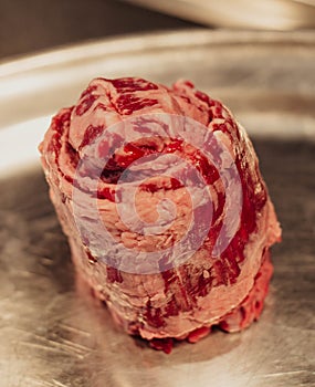 Raw beef meat on stainless steel plate. Selective focus. Toned.