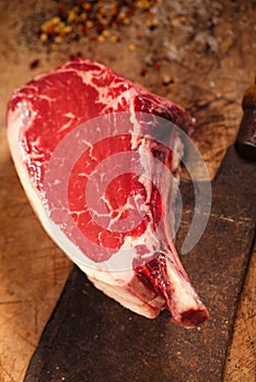 Raw beef meat steak on wooden table with meat cleaver