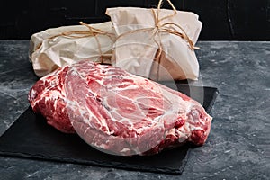 Raw beef neck tenderloin, gray background, eco packaging. Delivery of products, copies of the space.