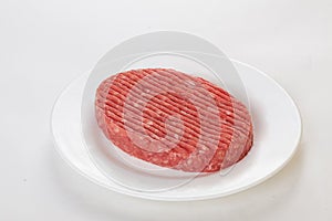 Raw beef patties on a plate isolated