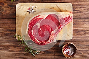 Raw beef Rib bone steak on wooden board and table