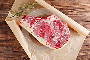 Raw beef Rib steak with bone on wooden board and table