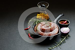 Raw beef sausages on a cast-iron pan, selective focus