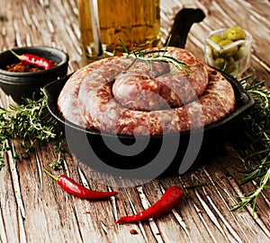 Raw beef sausages on a cast-iron pan, selective focus