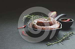 Raw beef sausages on a cast-iron pan, selective focus