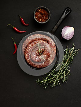 Raw beef sausages on a cast-iron pan, selective focus