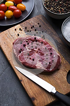 Raw beef sirloin steak with peppercorn and salt on cutting board