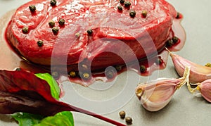 Raw beef sirloin steak with peppercorns and garlic prepared for frying