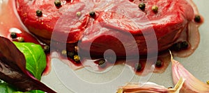 Raw beef sirloin steak with peppercorns and garlic prepared for frying