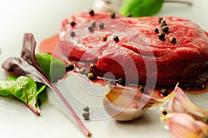 Raw beef sirloin steak with peppercorns and garlic prepared for frying