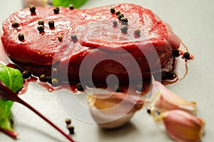 Raw beef sirloin steak with peppercorns and garlic prepared for frying