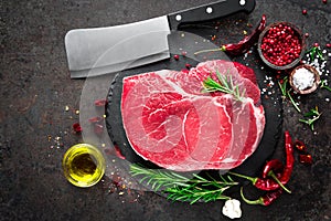 Raw beef steak on black background with cooking ingredients. Fresh beef meat