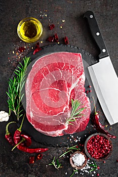 Raw beef steak on black background with cooking ingredients. Fresh beef meat