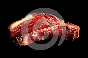 Raw beef steak on a black background whit copy space and cutting light