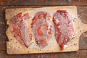 Raw beef steak and spicel on cutting board