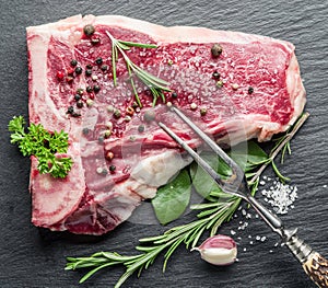 Raw beef steak with spices on the board.