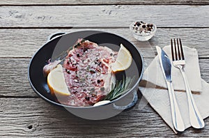 Raw beef steak with spices and herbs.