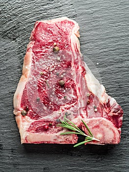 Raw beef steaks on the black cutting board.