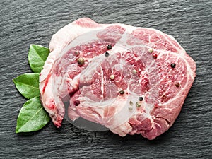 Raw beef steaks with spices on the cutting board.