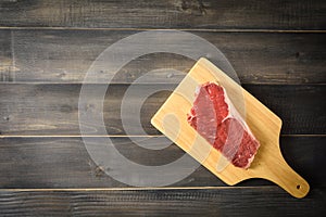 Raw beef striploin steak on cutting board