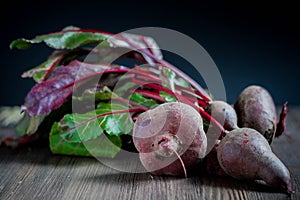 Raw beetroot with green leaves on a wooden table