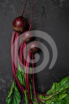 Raw beetroot. Organic red beetroot with herbage green leaves on a dark background. vertical image. top view. place for text