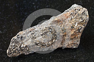 raw biotite nepheline syenite stone on dark photo