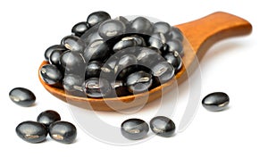Raw black bean in the wooden scoop, isolated on white