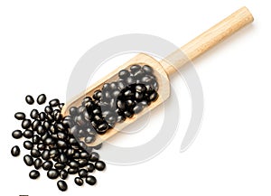 Raw black bean in the wooden scoop, isolated on white, top view