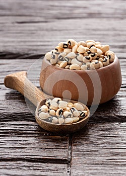 Raw black eye beans in the bowl and wooden spoon