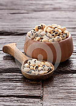 Raw black eye beans in the bowl and wooden spoon photo