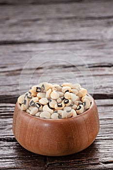 Raw black-eyed beans in the wooden bowl - Alubia carilla photo