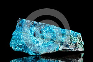 Raw blue apatite mineral stone in front of black background photo