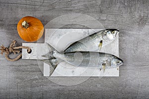 Raw Bluefish. Latin; Pomatomus Saltatrix. Fresh fish with the vegetables, condiment and lemon, bluefish. Food preparation photo