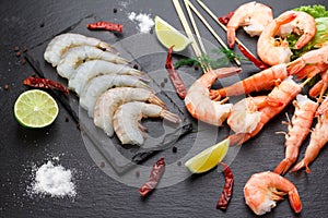 Raw and boiled shrimps on a stone plate
