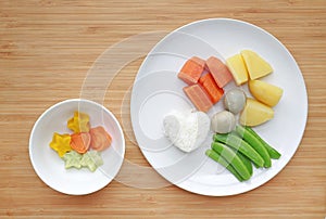 Raw of boiled vegetables baby food carrot, egg, potato, rice and sweet pea in white plate with frozen mashed baby food homemade