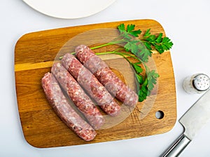 Raw botifarra from minced pork on wooden surface