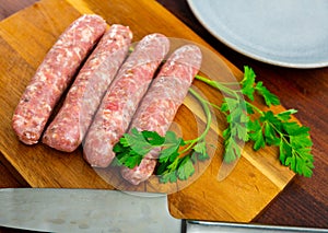 Raw botifarra from minced pork on wooden surface