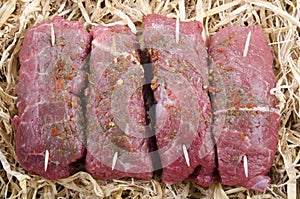 Raw braising steak in straw