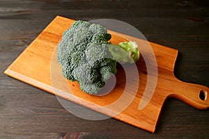 Raw broccoli isolated on a wooden chopping board