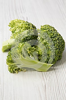 Raw broccoli on white wooden table