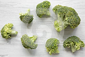 Raw broccoli on white wooden table