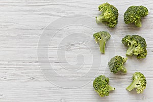 Raw broccoli on white wooden table, top view. Overhead, from above, flat lay.