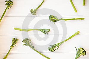 Raw broccolini on white table