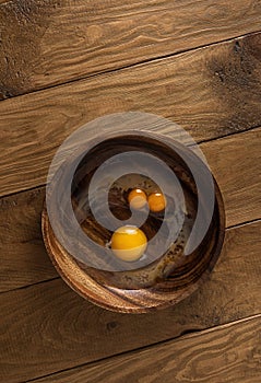 Raw broken chicken eggs look like funny face in bowl with copy space