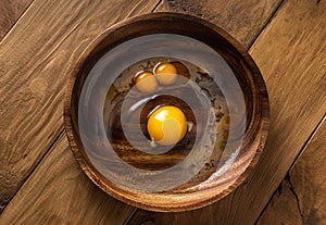 Raw broken chicken eggs look like funny face in wooden bowl