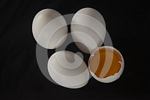 raw broken egg on a black background. chicken egg yolk. andai ki zardi. muttai. andai. egg. photo