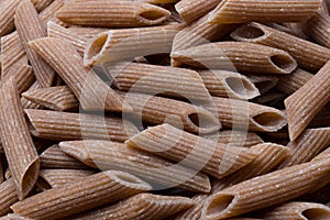 Raw brown pasta - background food concept