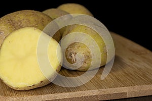 Raw brown potato isolated on black glass